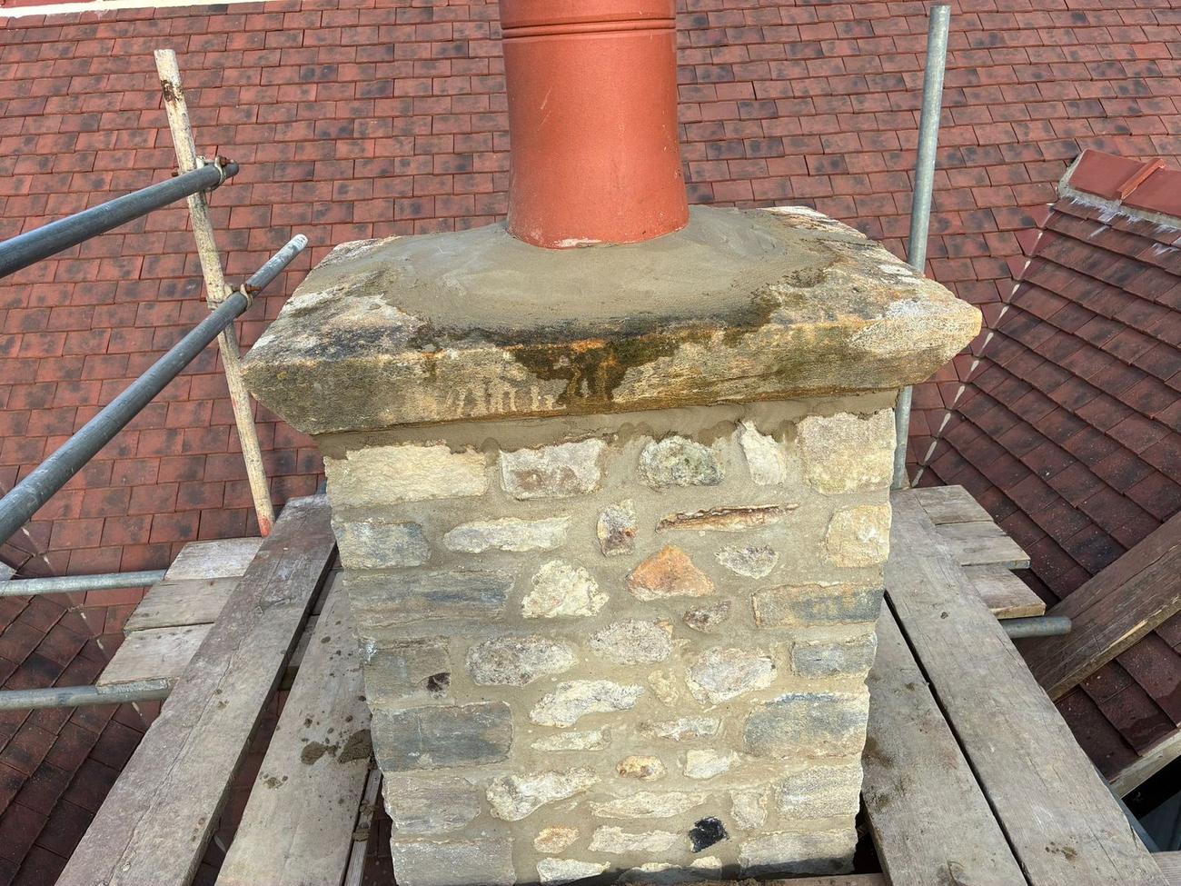 Chimney stack rebuilt in stone with a new cap and clay pot
