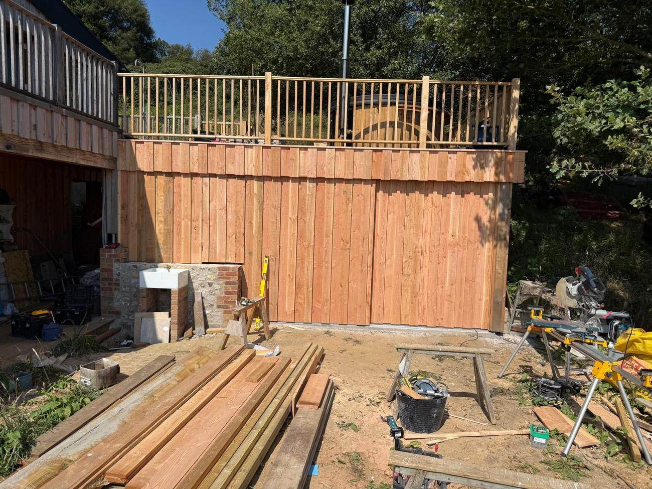 Raised timber deck with balustrade and vertical cladding under construction