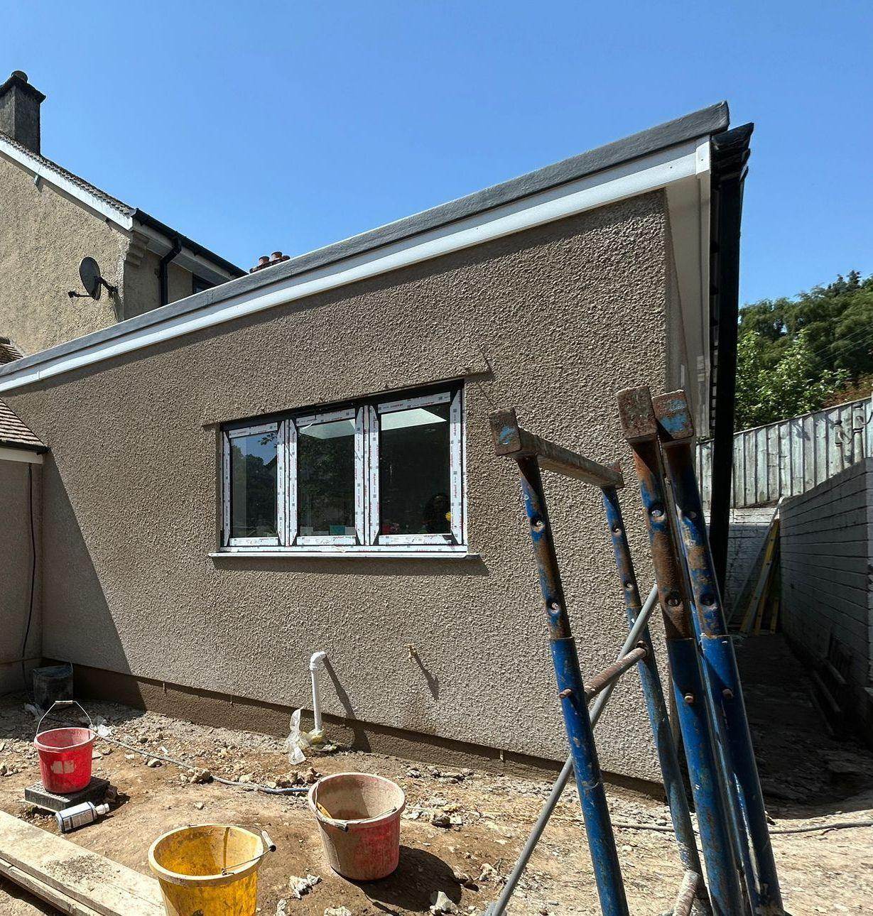 Rendered extension with a new window and flat roof detail